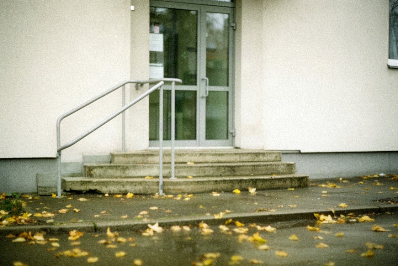 Schody i przeszklone drzwi urzędu w małym mieście na północnym Mazowszu, jesienny poranek